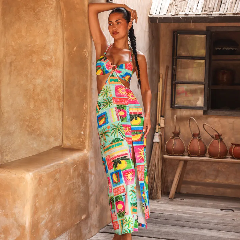 Woman in a colorful beaded maxi dress in a sunlit doorway
